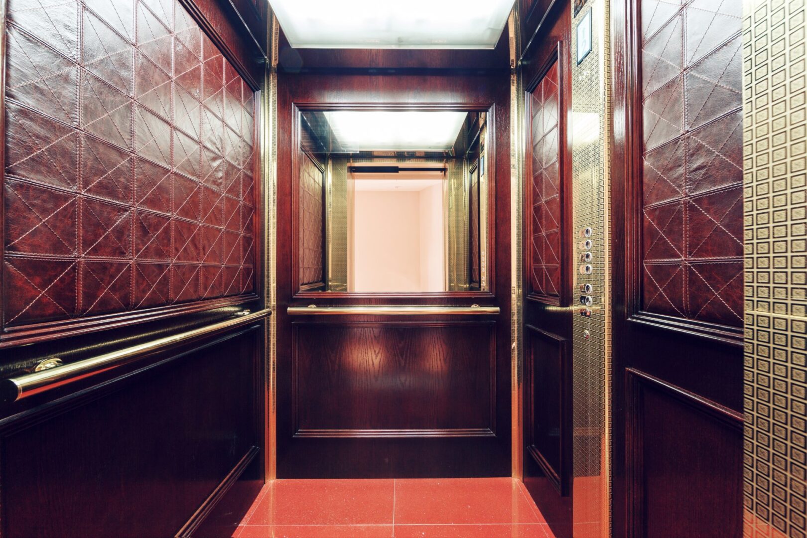 Custom elevator cab interior with walnut millwork panels and brass inlays by CNS Elevator Cabs